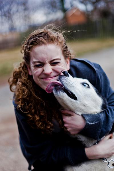 Photo of a dog kissing a woman